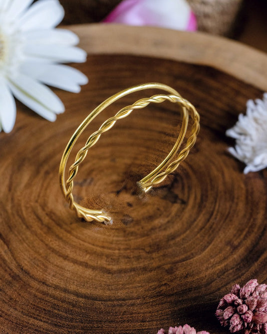 Gold bracelet on a wooden surface with flowers